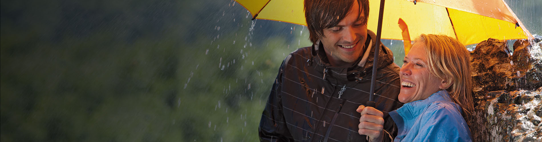 Lady and a gentleman hiking with a trekking and hiking umbrella in yellow