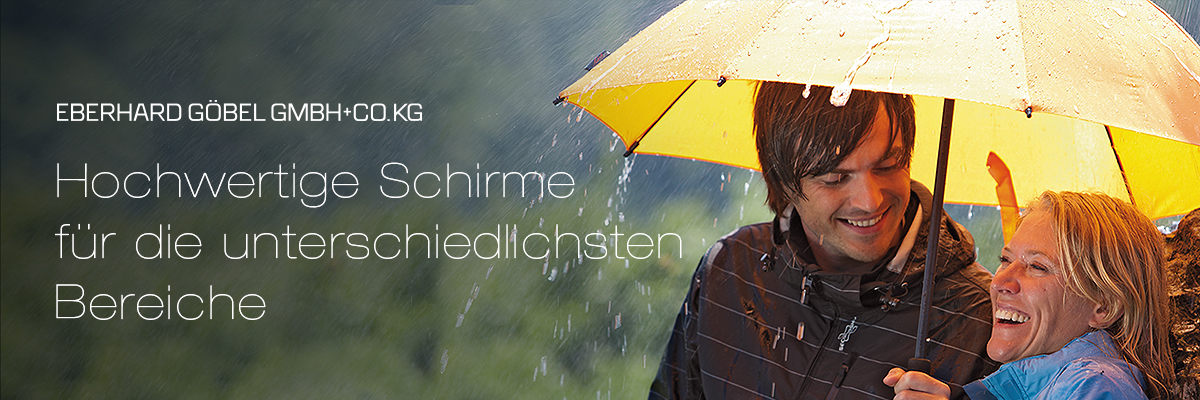 View of a gentleman and a lady holding a yellow umbrella from EuroSCHIRM, sitting together and leaning against a boulder.