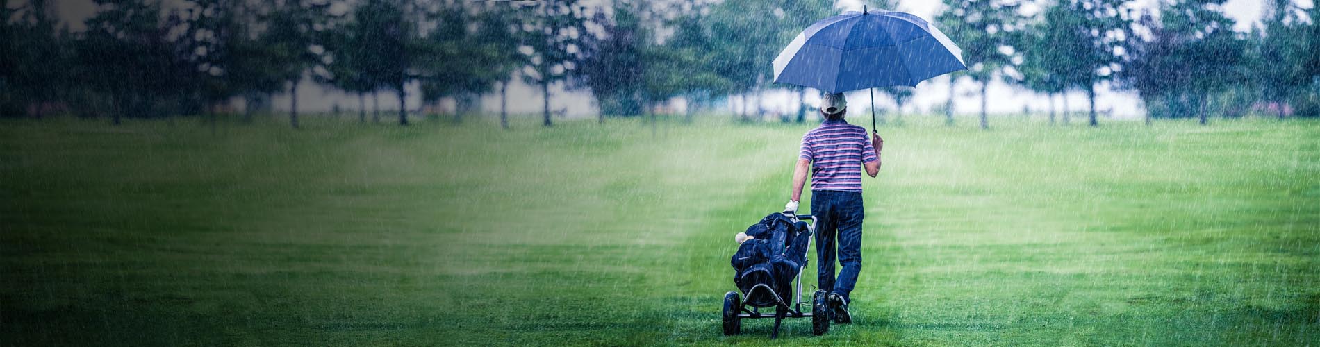 Premium umbrellas for golfers View of a golfer on the golf course with an opened golf - umbrella from EuroSCHIRM in action.