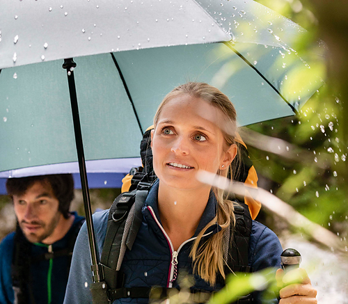 View of the opened trekking and hiking  Swing handsfree umbrella in olive green in use